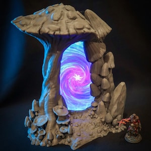 Peut inclure: Une miniature imprim&eacute;e en 3D d'un portail en forme de champignon avec une lumi&egrave;re bleue et violette tourbillonnante &eacute;manant du centre. Le portail est entour&eacute; de petits champignons et de rochers.