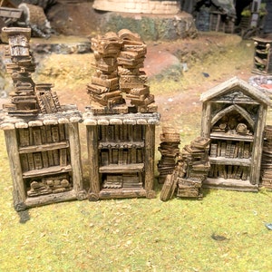 May include: A set of three wooden bookcases with shelves filled with miniature books. The bookcases are made of a light brown wood and have a rustic, aged look. The bookcases are perfect for adding a touch of fantasy to any tabletop game or miniature collection.