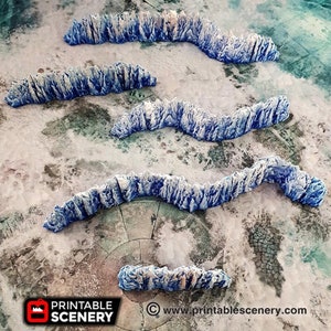 May include: Five blue and white 3D printed ice wall pieces for tabletop gaming. The walls are curved and have a jagged, icy texture.  Printable Scenery is printed on the bottom right corner of the image.