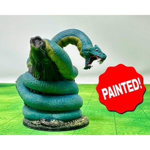 Könnte beinhalten: Eine bemalte Miniatur einer grün-blauen zweiköpfigen Schlange, die sich um einen Baumstamm windet. Die Schlange hat einen bedrohlichen Ausdruck und ist bereit zum Angriff. Die Miniatur steht auf einem grünen Sockel und ist mit "PAINTED!" beschriftet.