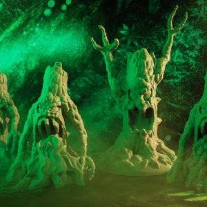 May include: Four green, mossy, tree-like creatures with gnarled branches and faces. They are standing on a dark background with green lighting.