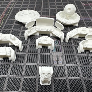 May include: A set of nine white 3D printed miniature spaceship bridge console pieces. The consoles are designed to be used in tabletop games or as decorative pieces.