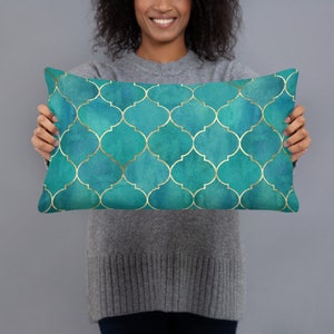 May include: A teal blue and gold decorative pillow with a geometric pattern. The pillow is made of soft fabric and has a subtle sheen.