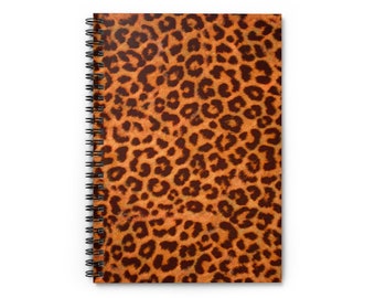 May include: A spiral bound notebook with a brown and orange leopard print cover.
