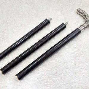 Puede incluir: Tres bastones de madera negra con mangos de metal plateado. Los mangos son ornamentados y tienen un dise&ntilde;o floral.