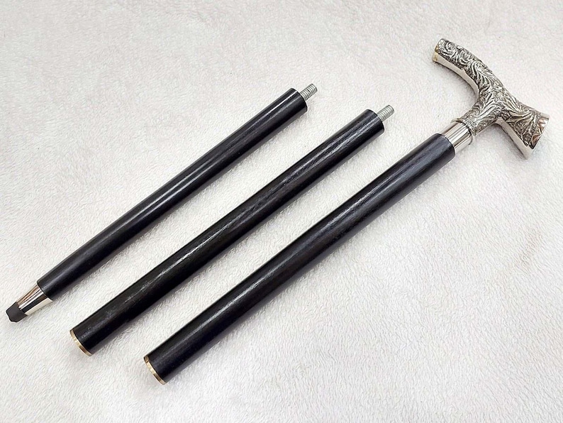 Puede incluir: Tres bastones de madera negra con mangos de metal plateado. Los mangos son ornamentados y tienen un dise&ntilde;o floral.