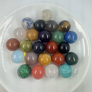 Peut inclure: Une collection de 25 sphères de pierres précieuses polies de différentes couleurs et textures, notamment l'améthyste, la turquoise, l'œil de tigre et le quartz rose.