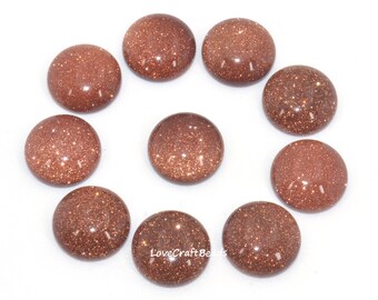 May include: Ten round, brown, sandstone cabochons. Each cabochon has a sparkly, glittery texture.