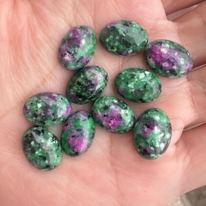 Könnte beinhalten: Ovale, grüne, rosa und schwarze Edelsteine ​​in Cabochon-Schliff.