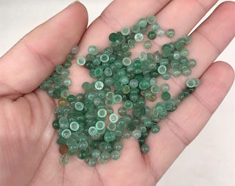 May include: A close-up of a pile of small, round, green gemstone beads. The beads are smooth and shiny, and they are ideal for jewellery making.