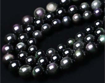 May include: A strand of black obsidian beads with iridescent rainbow shimmer. The beads are round and smooth, and they are strung on a clear thread.