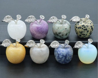 May include: Eight crystal apple figurines with silver leaves and stems. The apples are in various colors, including white, purple, green, brown, yellow, gray, blue, and orange.