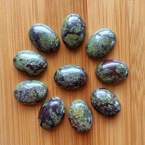 May include: Twelve oval-shaped green, black, and red stones with a speckled pattern.