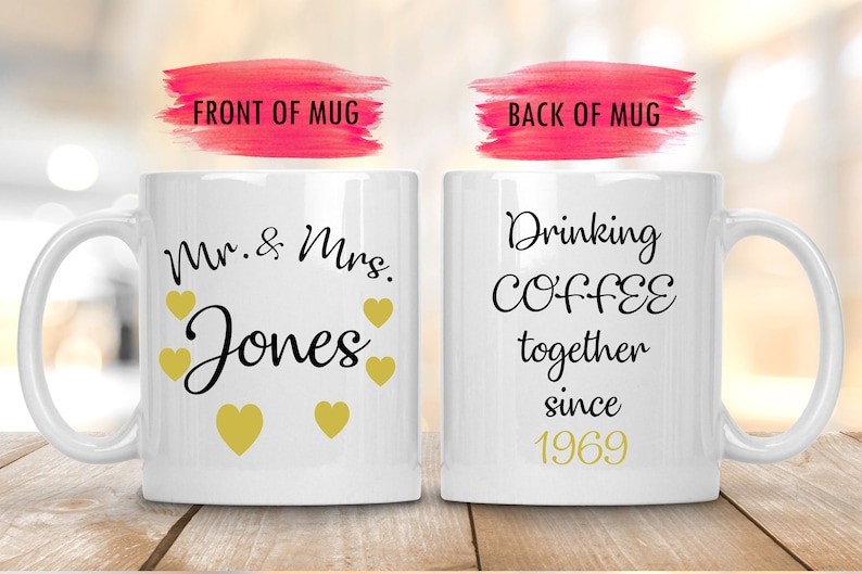 May include: Two white coffee mugs with black text. The front mug says "Mr. & Mrs. Jones" with gold hearts. The back mug says "Drinking COFFEE together since 1969".