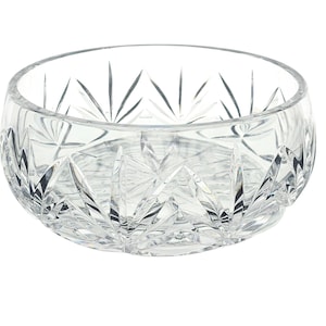 Peut inclure: Un bol en verre transparent avec un motif en cristal taillé. Le bol est rond et a un bord large.
