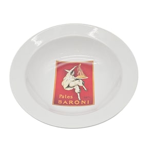 May include: White ceramic pasta bowl featuring a red and brown graphic of a person holding pasta, with the text "Pâtes BARONI". The bowl has a wide rim and a deep centre, ideal for serving pasta dishes.
