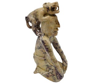 マヤの戦士の彫刻、手作りの粘土像、羽根飾りの頭飾りの像、盾と容器の