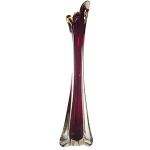 Peut inclure: Un vase en verre haut et fin avec une forme organique unique. Le vase est en verre clair avec une teinte rouge foncé. Le haut du vase a une ouverture évasée, tandis que le fond est légèrement plus large et a une base arrondie.