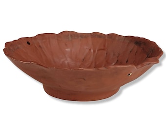 May include: A terracotta bowl with a scalloped edge and a textured surface. The bowl is a reddish-brown color.