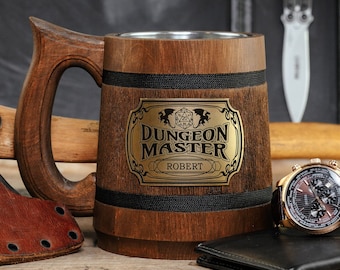 May include: A brown wooden beer stein with a black band and a gold metal plaque that reads "Dungeon Master Robert". The stein is sitting on a wooden surface next to a black leather wallet, a watch, and an axe.