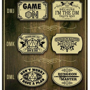 May include: Six different designs of Dungeon Master badges. The badges are all yellow with black text and images. The badges feature a variety of designs, including a dice, a dragon, and a sword. The text on the badges includes "Game On", "Because I'm the DM", "Swords Don't Kill DM's Do", "Dungeon Master", "Don't Worry I Have a Plan", and "Dungeon Master".