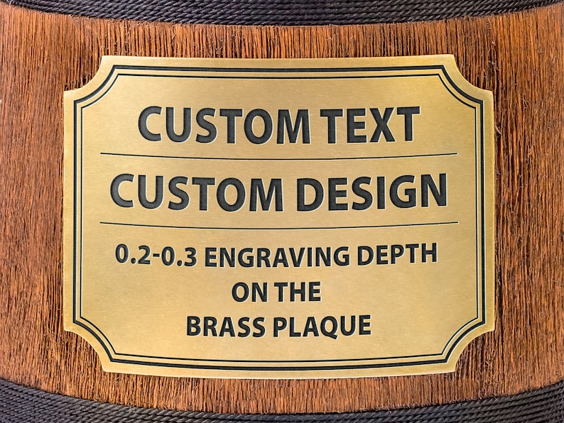 May include: A gold-colored brass plaque with a black border and rounded corners. The plaque has the text "CUSTOM TEXT" and "CUSTOM DESIGN" in black lettering. Below the text is the phrase "0.2-0.3 ENGRAVING DEPTH ON THE BRASS PLAQUE".