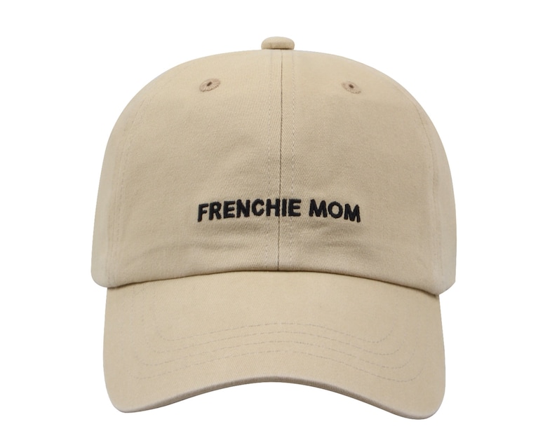 May include: A beige baseball cap with black embroidered text that reads "FRENCHIE MOM".
