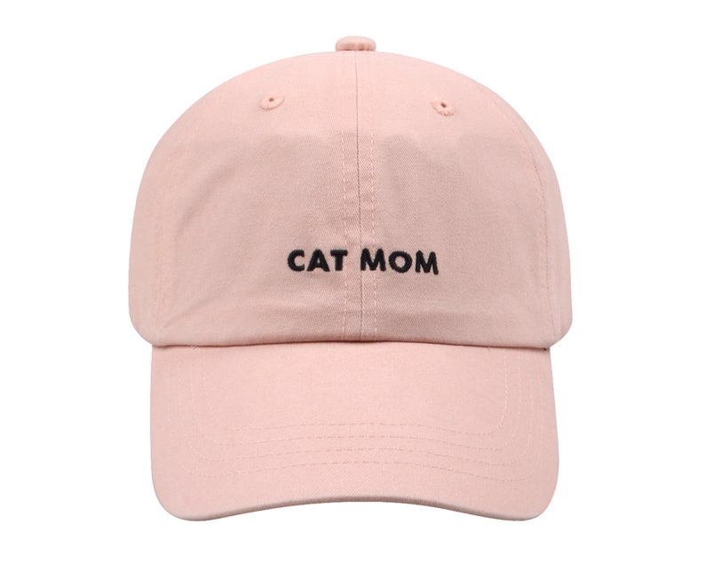 Pu&ograve; includere: Un berretto da baseball rosa con ricamo nero che recita "CAT MOM".