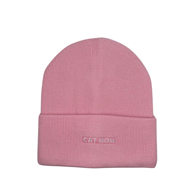 Puede incluir: Gorro de punto rosa con el texto "CAT MOM" bordado en la parte delantera.