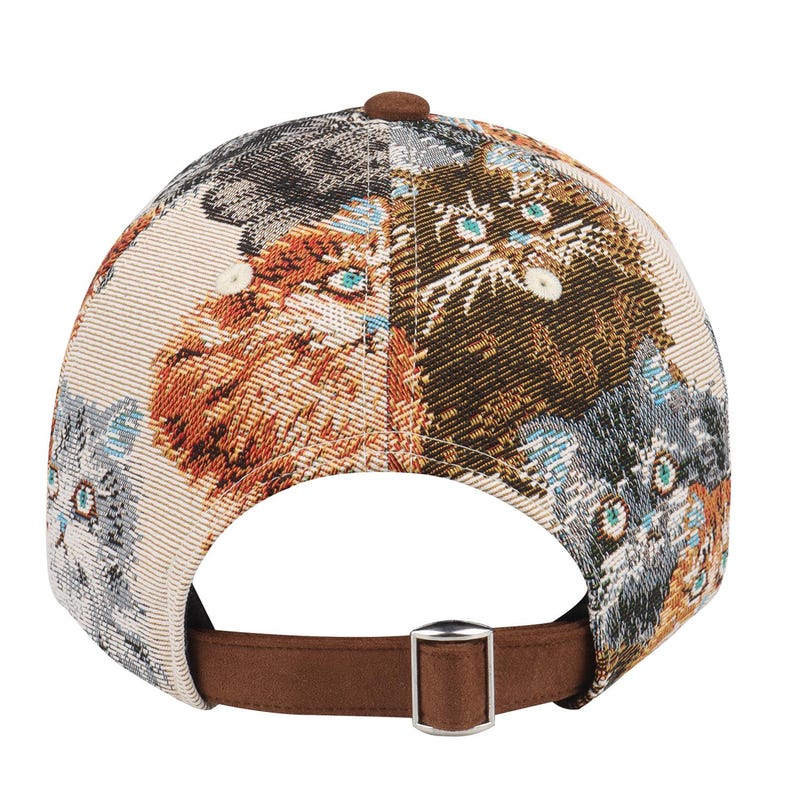 May include: A baseball cap with a cat tapestry design. The cap features a brown suede brim and adjustable strap. The crown of the cap is beige with a repeating pattern of cat faces in shades of brown, gray, and orange.