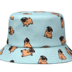 May include: A light blue bucket hat with a pattern of brown pugs. The pugs are in various poses, some are sitting, some are standing, and some are looking at the camera.