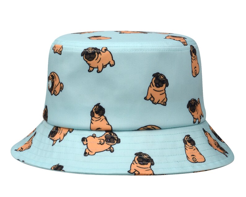 May include: A light blue bucket hat with a pattern of brown pugs. The pugs are in various poses, some are sitting, some are standing, and some are looking at the camera.