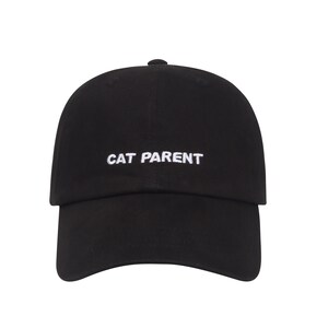 May include: A black baseball cap with white embroidered text that reads "CAT PARENT".