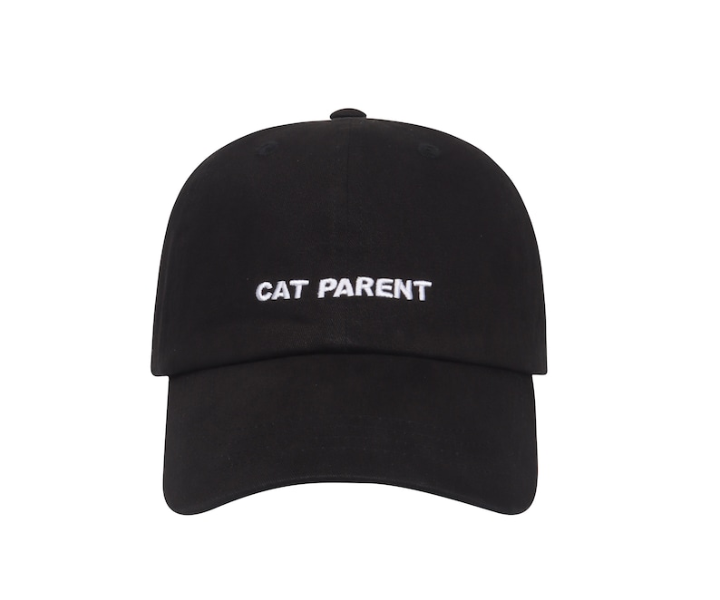 May include: A black baseball cap with white embroidered text that reads "CAT PARENT".