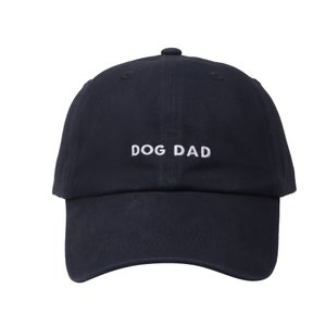 May include: A navy blue baseball cap with white embroidered text that reads "DOG DAD".