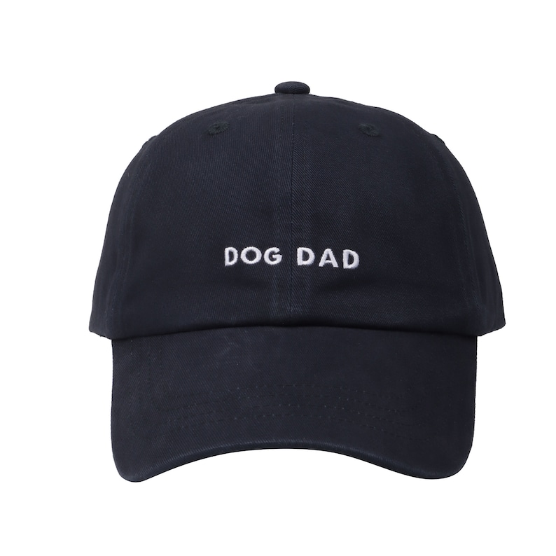 May include: A navy blue baseball cap with white embroidered text that reads "DOG DAD".