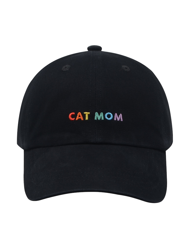 Pu&ograve; includere: Un cappello da baseball nero con le parole "CAT MOM" ricamate in colori arcobaleno.