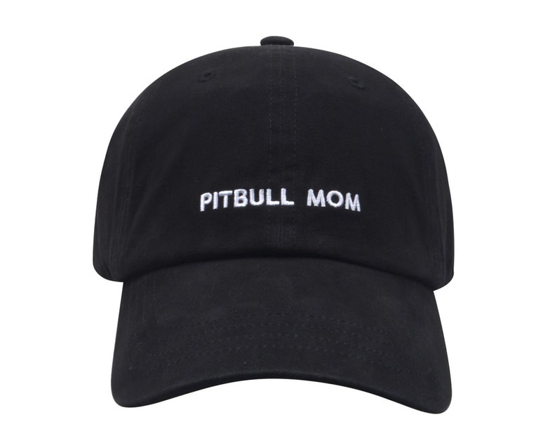May include: A black baseball cap with white embroidered text that reads "PITBULL MOM".