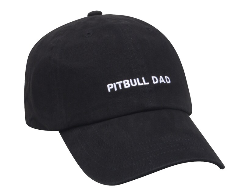 May include: Black baseball cap with a white embroidered text that reads "PITBULL DAD".