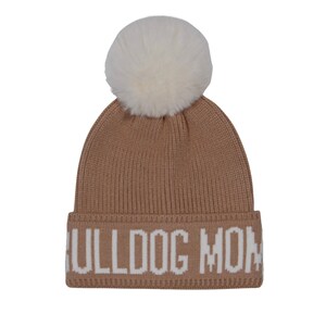 Pode incluir: Um gorro de malha bege com um pompom de pele sint&eacute;tica branca. O chap&eacute;u apresenta o texto "BULLDOG MOM" em letras brancas na aba. Um acess&oacute;rio de inverno aconchegante.