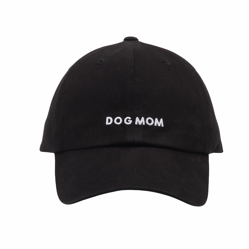 May include: Black baseball cap with white embroidered text that reads "DOG MOM".