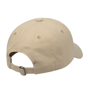 May include: A beige baseball cap with a curved brim and an adjustable strap. The cap is made of a soft, cotton fabric.