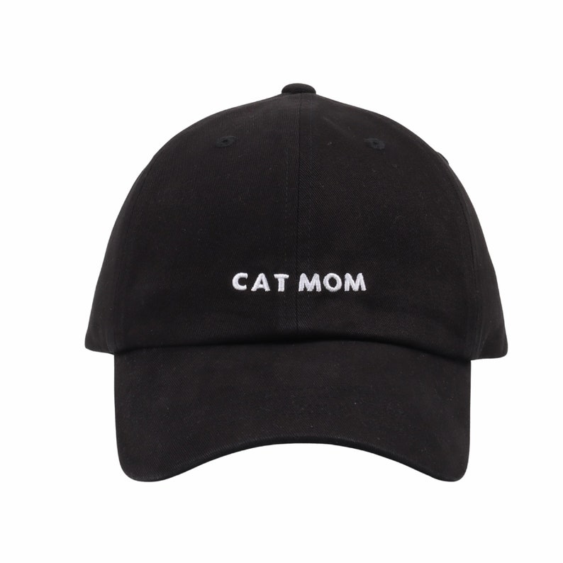 Pu&ograve; includere: Un cappello da baseball nero con testo ricamato in bianco che recita "CAT MOM".