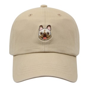 May include: A beige baseball cap with an embroidered image of a French bulldog on the front.
