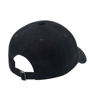 K&ouml;nnte beinhalten: Eine schwarze Baseballkappe mit einem gebogenen Schirm und einem verstellbaren Riemen.