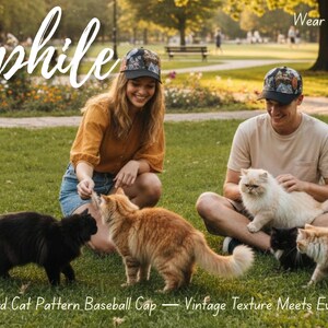May include: A couple wearing matching baseball caps with a cat pattern, sitting on the grass with several cats. The caps have a vintage texture. The image includes the text "Hatphile" and "Wear Art. Wear Cats."