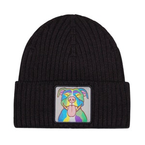 May include: Black knit beanie with a colorful dog face patch. The dog has a rainbow colored body and a pink tongue sticking out.