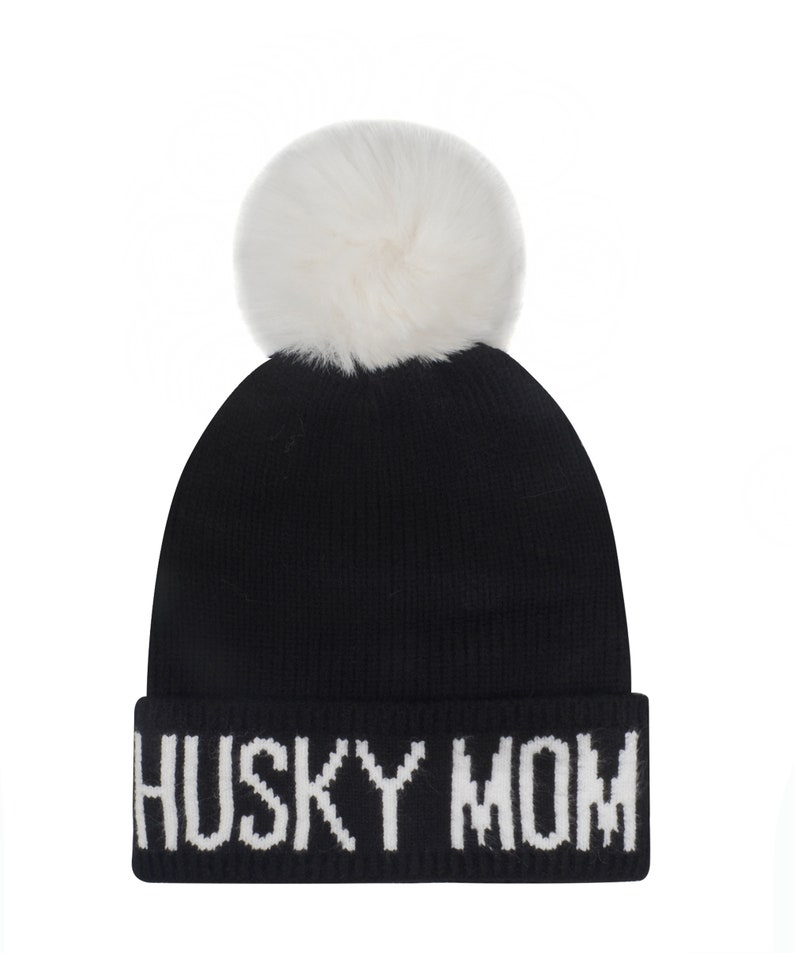 May include: Black knit beanie with a white pom pom and the words "Husky Mom" in white lettering.
