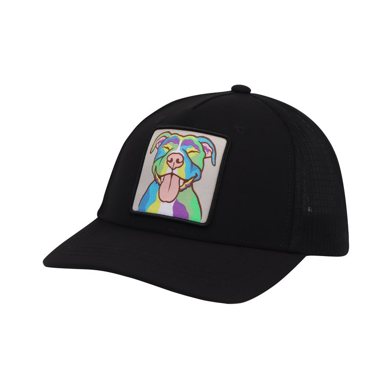 Op de afbeelding: Zwarte mesh truckercap met een kleurrijk cartoon hondje erop. De hond lacht met zijn tong naar buiten.