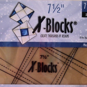 May include: A clear plastic quilting ruler with a brown background. The ruler is labeled "7 1/2" X-Blocks" and has a grid pattern. The ruler is packaged in a clear plastic bag with a blue and white background. The bag also has the text "7 1/2" X-Blocks" and "Create Thousands of Designs".
